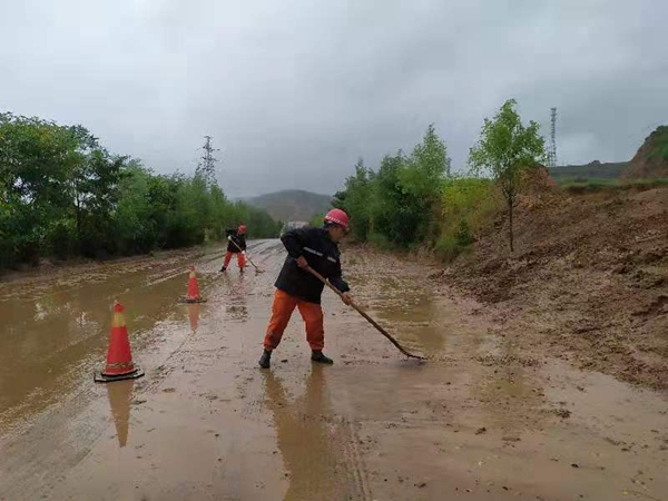 8月20日，张家川公路段工作人员冒雨在张恭二级公路K6+200`清理泥石流.jpg